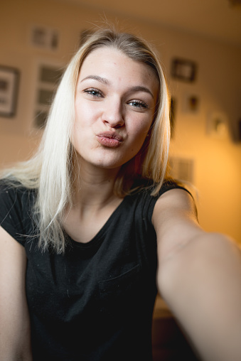 Beautiful Cheerful Teenage Girl Taking A Selfie In Bedroom Stock