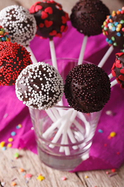 Beautiful chocolate cake pops with colorful candy sprinkles close up...