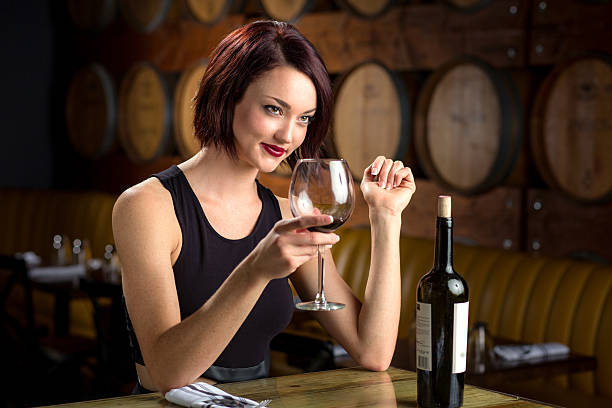 Beautiful classy woman cheers glass bottle red wine winery restaurant stock photo