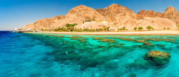 Beautiful coral reefs of the Red Sea, sandy beaches, tourist resort bungalows and mountains near Eilat, Israel stock photo