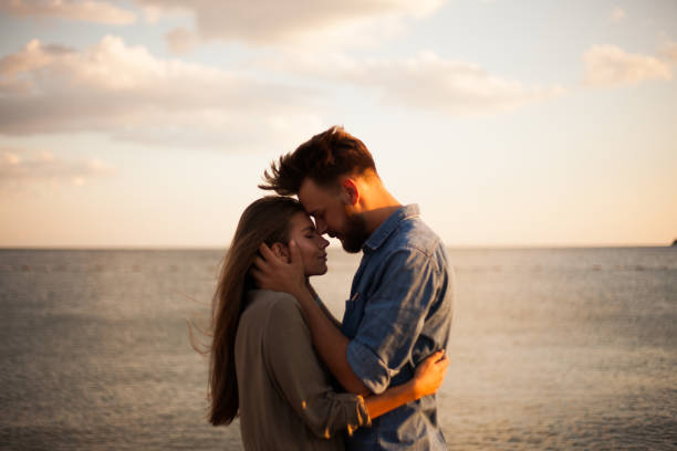 Beautiful couple kissing on the beach stock photo