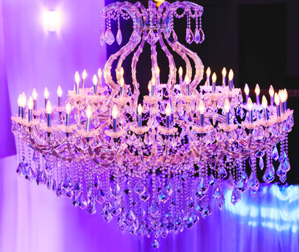 Beautiful Crystal Chandelier. Close up on the crystal of a contemporary crystal decoration. Luxury luster in the banquet hall. Great close-up photo of crystal chandelier on the blue background. Glamour crystal glass in modern room. stock photo