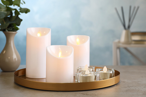 Beautiful decorative LED candles on grey table