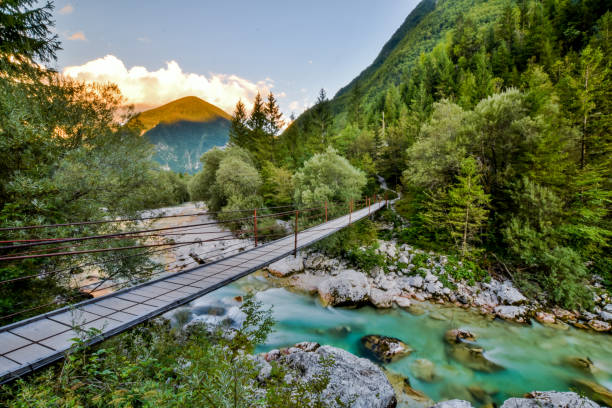 Beautiful evening view of a bridge crossing over Soca River, one of the most beautiful European rivers running through the Soca Valley near Triglav National Park in Slovenia. stock photo