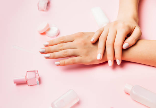 Beautiful female hands with trendy stylish manicure on pink background. Beautiful female hands with trendy stylish manicure on pink background. Multicolored Bottles of nail polish. Top view, flat lay. gel nail polish stock pictures, royalty-free photos & images