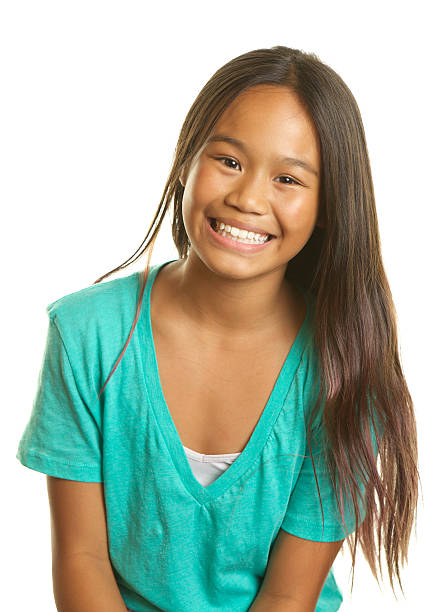 Beautiful Filipino Girl on a White Background Smiling A beautiful Filipino girl smiling on a white background.  She has long hair and is eleven years old. philippine girl stock pictures, royalty-free photos & images