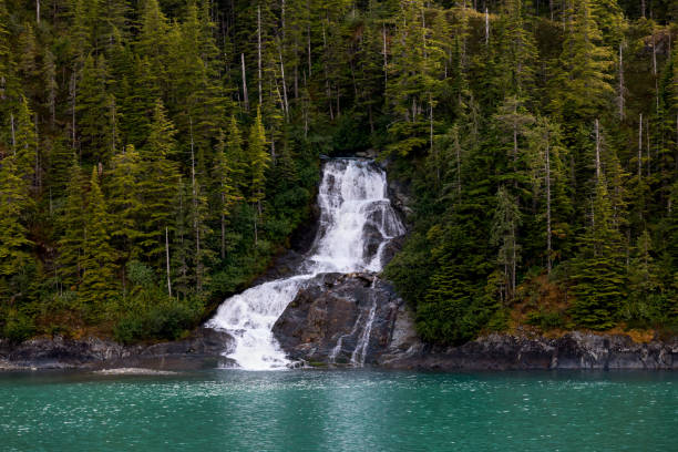 Beautiful flowing waterfall into the ocean in Endicott Arm, Alaska stock photo