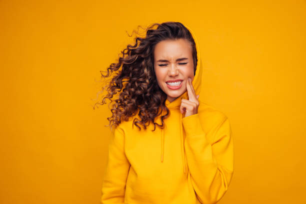 vacker flicka i en gul tröja med tandvärk - toothache woman bildbanksfoton och bilder