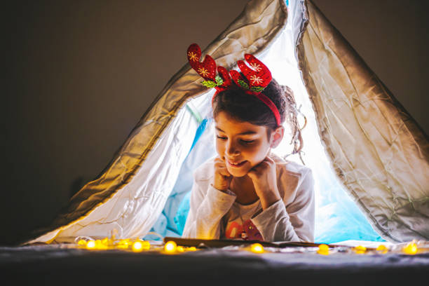 Beautiful happy smiling girl laying on the bed /Christmas decorations Beautiful happy smiling girl laying on the bed with toys and Christmas decorations christmas story telling stock pictures, royalty-free photos & images