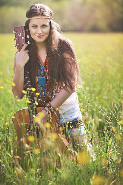 Beautiful hippie woman posing with guitar stock photo