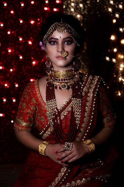 Beautiful indian girl in bride look wearing red lehanga and gold jewellery Beautiful young indian girl in bride look wearing red lehanga and gold jewellery indian bride stock pictures, royalty-free photos & images