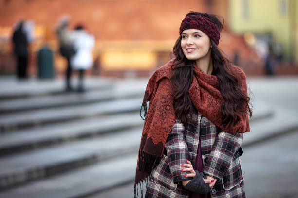 Beautiful joyful woman portrait in a city. Smiling  girl wearing warm clothes and hat  in winter or autumn stock photo