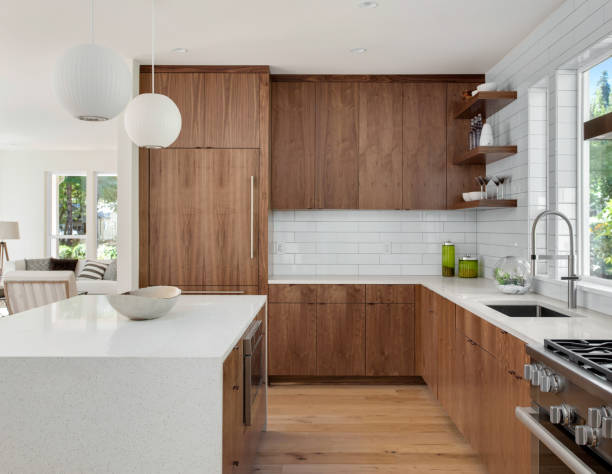 mooie keuken in nieuwe luxe huis met island, hanger lichten en hardhoutvloeren - kookeiland stockfoto's en -beelden