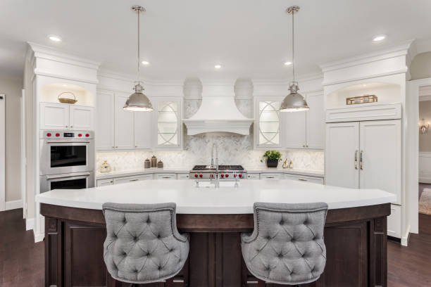 beautiful kitchen in new luxury home with island, pendant lights, and hardwood floors stock photo