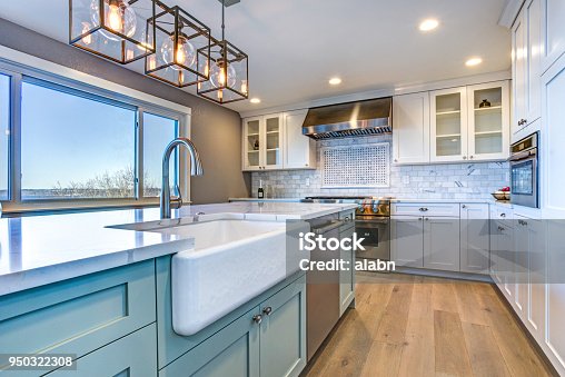 istock Beautiful kitchen room with green island and farm sink. 950322308