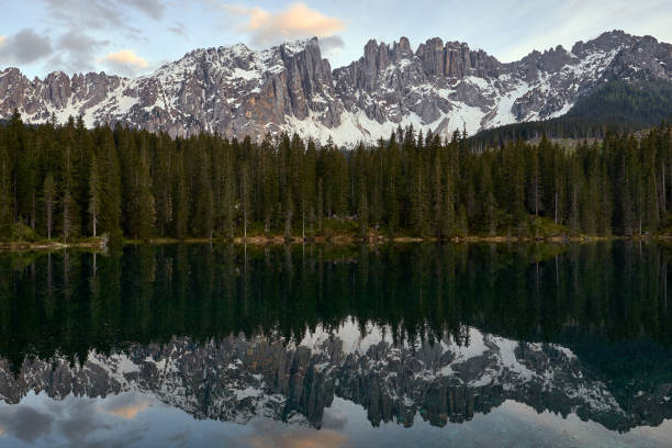 beautiful landscape of the lago di carezza with the reflection of the mountain and pine trees in the lake in the Italian Dolomites stock photo