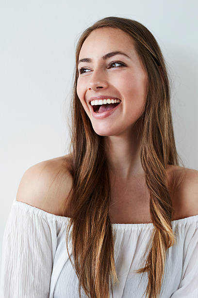 Beautiful laughing lady in white, studio stock photo