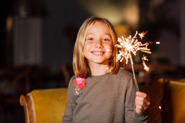 Beautiful little girl with sparkles Lovely little girl playing with sparkles and waiting for the new year's eve new years eve girl stock pictures, royalty-free photos & images