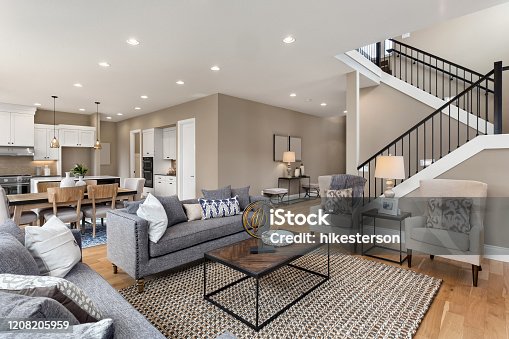 istock Beautiful living room interior with hardwood floors and and view of kitchen in new luxury home 1208205959