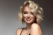 istock Beautiful looking young blonde woman with the middle length hair, wearing in a delicate makeup. Elegance and hairstyling. 1322686195