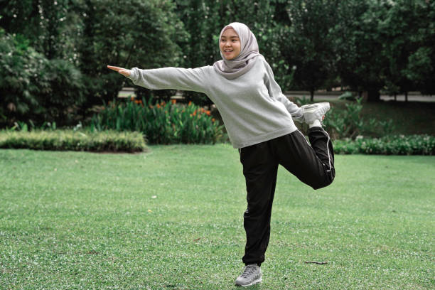 Beautiful muslim teenager doing exercise at a public park during a sunny day stock photo
