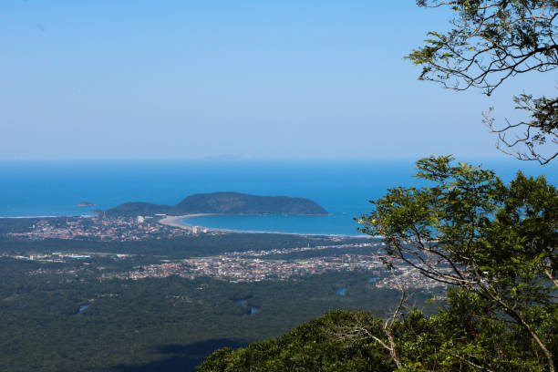 Beautiful panoramic view of green tropical forest, blue sky and beach of Bertioga city in the background stock photo