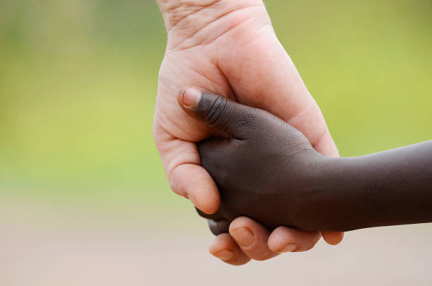 Beautiful Peace Symbol - White Woman Black Child Holding Hands stock photo