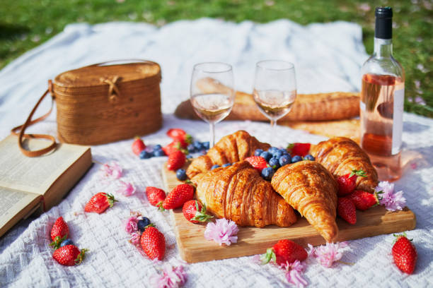 Beautiful picnic with rose wine, French croissants and fresh berries stock photo
