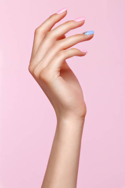 Beautiful pink and blue manicure with crystals on female hand. Close-up. Beautiful pink and blue manicure with crystals on female hand. Close-up. Picture taken in the studio painting fingernails stock pictures, royalty-free photos & images