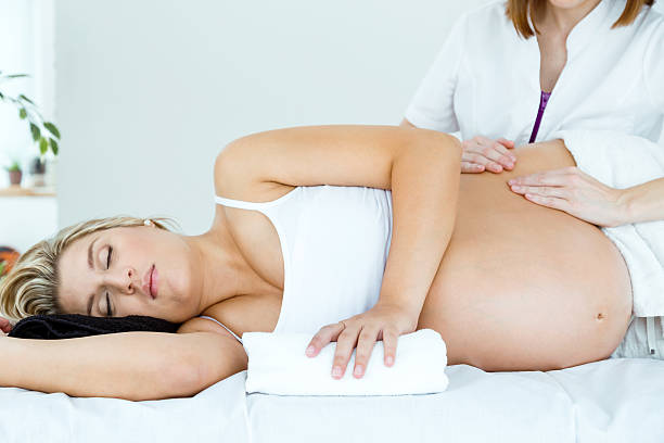 Beautiful pregnant woman having a massage in spa. Portrait of beautiful pregnant woman having a massage in spa. pregnancy pampering stock pictures, royalty-free photos & images