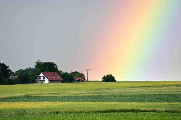 Beautiful rainbow over the village stock photo