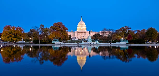 A beautiful reflection of United States Capitol at dawn The west face of the US Capitol at dawn reflecting in the Capitol Reflecting Pool. Autumn foliage. washington dc stock pictures, royalty-free photos & images