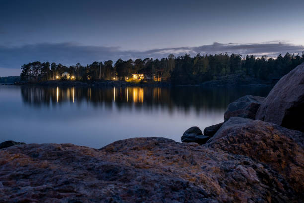 A beautiful scene of Helsinki archipelago with a cottage casting reflection on the water surface. stock photo