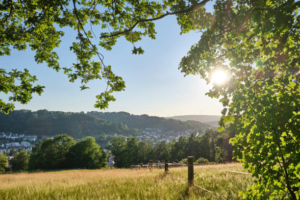 Beautiful scenic view into rural German summer landscape A beautiful scenic view with the evening sun into a rural German summer landscape in the Spessart with the town Bad Orb, Hessen hesse germany stock pictures, royalty-free photos & images