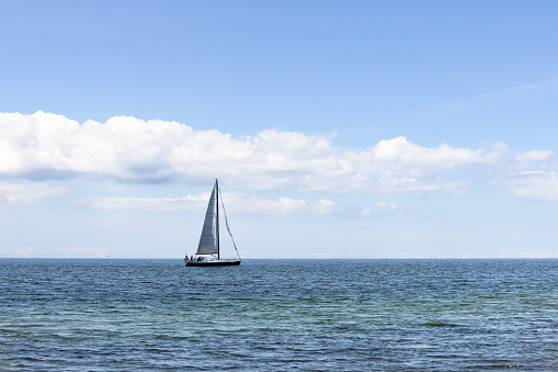 Beautiful seascape. Sailboat floats on the blue sea.