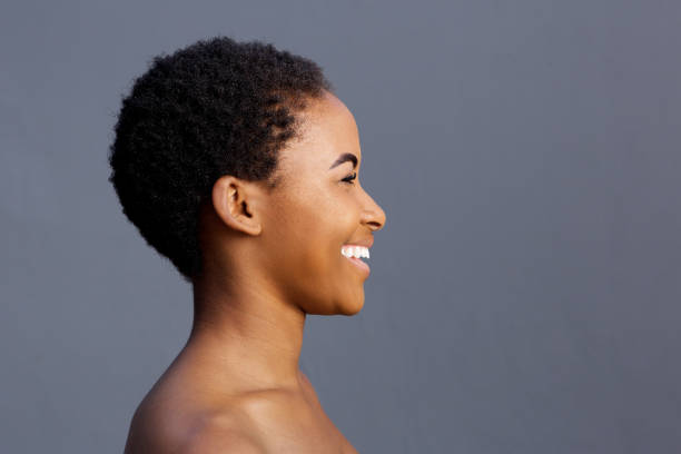 model wanita hitam tersenyum indah dengan latar belakang abu-abu - fotografi citra potret stok, foto, & gambar bebas royalti