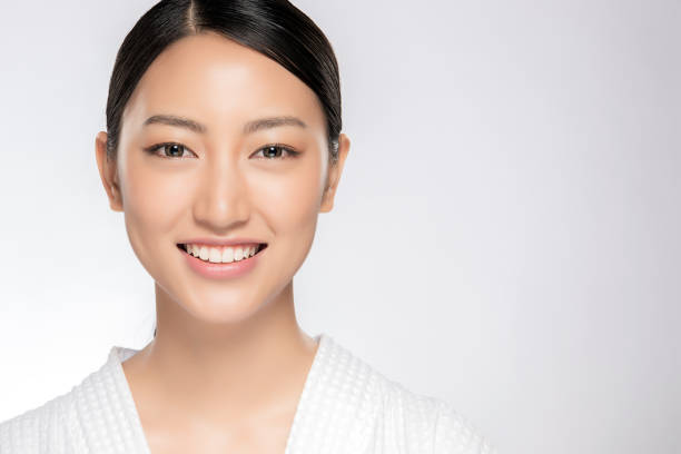 Beautiful smiling woman with clean skin Beautiful smiling woman with clean skin, natural make-up, and white teeth on white background beautiful asian woman face stock pictures, royalty-free photos & images