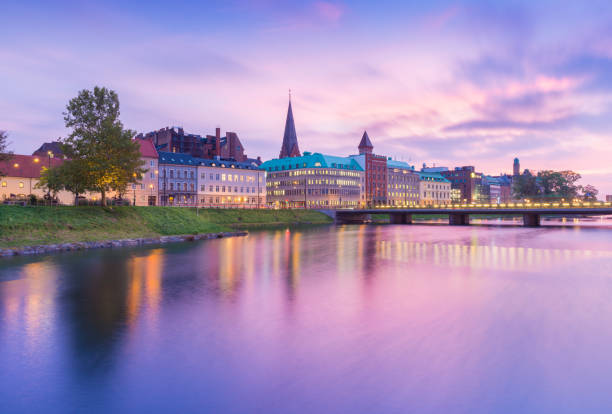 beautiful sunset in malmo, sweden. picturesque view of an old european city in the evening. skyline reflected in the water. long exposure photography - malmo imagens e fotografias de stock