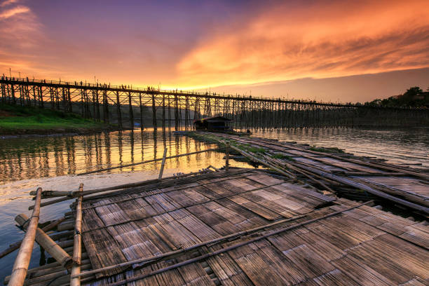Beautiful sunset, The river and old wooden bridge (Mon Bridge) in sunset at Sangklaburi, wooden bridge over the river, bamboo bridge, Kanchanaburi province, Thailand stock photo