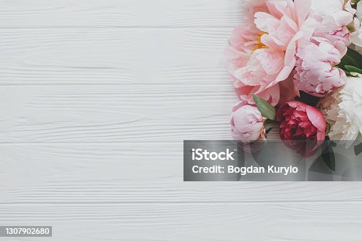 istock Beautiful tender peony flowers border on white wood, flat lay with copy space. Happy Mothers day 1307902680