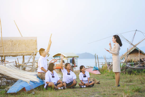 Beautiful Thai Teacher in uniform teaching student to learn natural things at outdoor stock photo