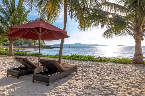 Beautiful tropical sea beach in Thailand, Beach chairs and umbrellas on the sandy beach near the sea.