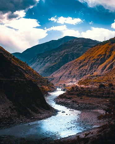 Scenic view of valley of mountains with river flowing in the midst against the sky.