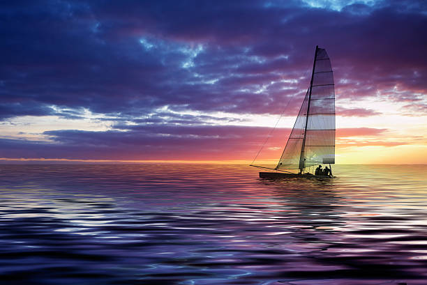 Beautiful view of sailboat in ocean during sunset stock photo