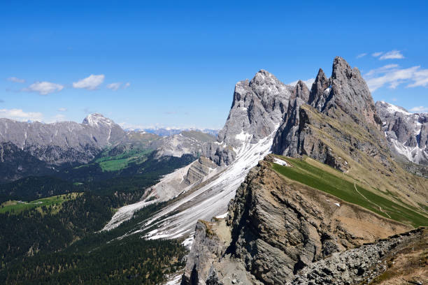 beautiful view of the top of mount seceda full of snow and a huge drop into the forest, panoramic view, in the italian dolomites, europe stock photo