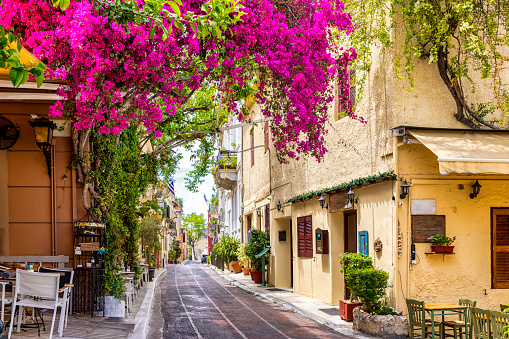 Beautiful view to the little streets of the old town Plaka of Athens, Greece with colorful houses and blooming bougainvillea flowers
