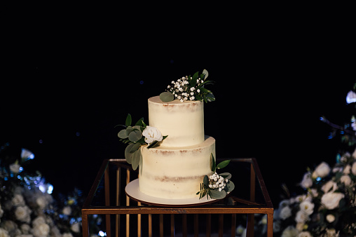 Beautiful wedding cake with flowers and a large wedding arch