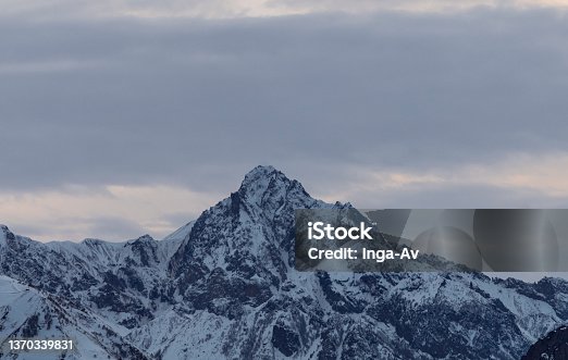 istock Beautiful winter mountain landscape at the sunrise with dramatics clouds. High snow covered mountains in the fog. 1370339831