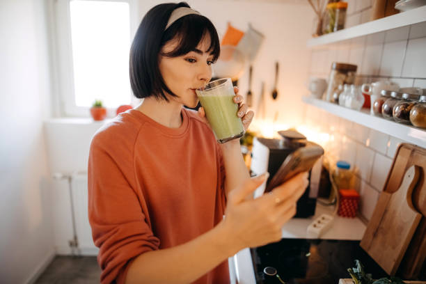 Beautiful woman drinking a green detox juice s stock photo