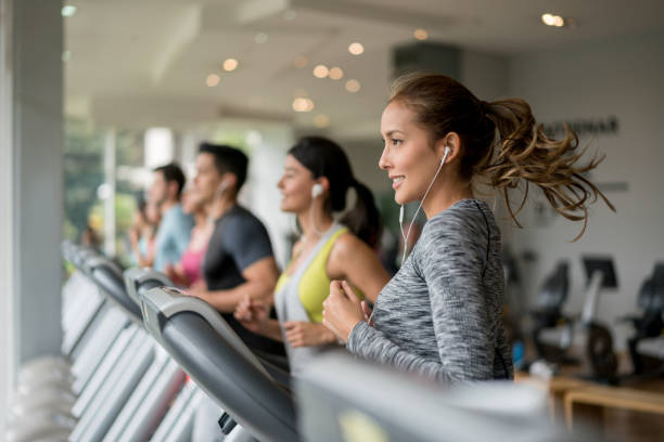 wanita cantik berolahraga di gym berjalan di treadmill - treadmill potret stok, foto, & gambar bebas royalti